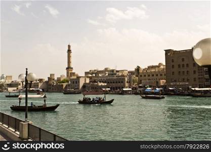 View of Dubai Creek with traditional boat taxi activity. The creek is dividing the city into two main sections: Deira and Bur Dubai