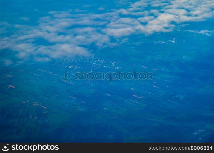view of earth from an airplane window above the clouds. European landscape.