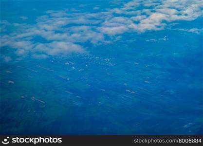 view of earth from an airplane window above the clouds. European landscape.