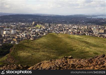 View of Edinburgh central city, including Edinburgh Castle, from Arthur&rsquo;s Seat which is an extinct volcano in Holyrood Park. This part of the park is bounded by the Salisbury Crags.
