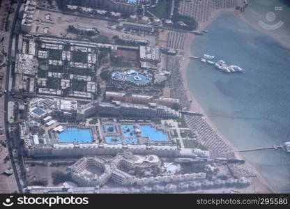 View of Egyptian resorts with swimming pools from plane. Tropical resorts, aerial view. Ranorama earth objects from air. Desert, oasis, pools and tourist spots. Tropical resorts with a bird's eye view. View of Egyptian resorts with swimming pools from plane. Tropical resorts