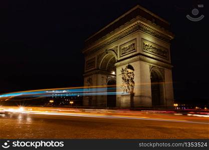 View of famous Arc de Triomphe in Charles de Gaulle square at night in Paris, France