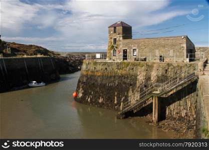 View of historic Amlwch Harbour with old lighthouse. Amlwch, Anglesey, Wales, United Kingdom. Once famous for copper trade.