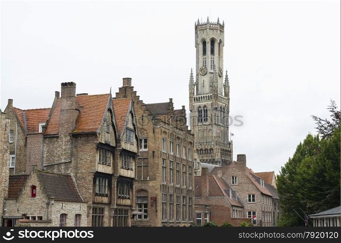 View of houses with Belfry of Bruges behind them.