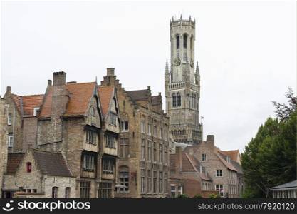 View of houses with Belfry of Bruges behind them.