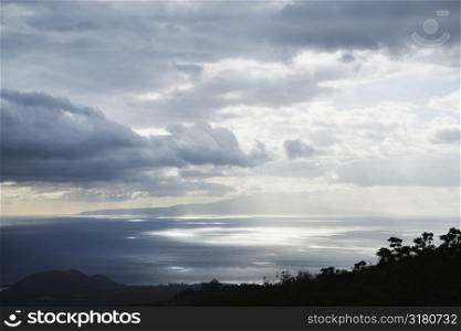 View of island in Pacific ocean with clouds from Maui, Hawaii.