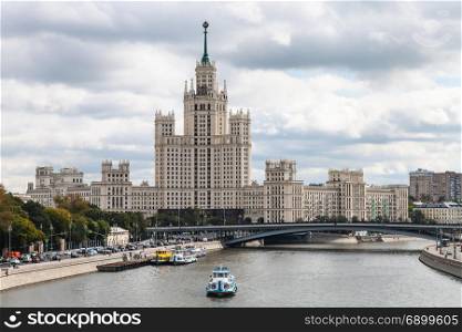 view of Kotelnicheskaya Embankment High-Rise Building and Bolshoy Ustinsky Bridge of Moskva River from Floating Bridge in Zaryadye park in Moscow city in autumn