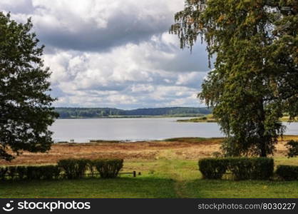 View of lake Petrovskoye (Kuchane) with footpath in green grass, Pushkinskiye Gory Reserve, Russia