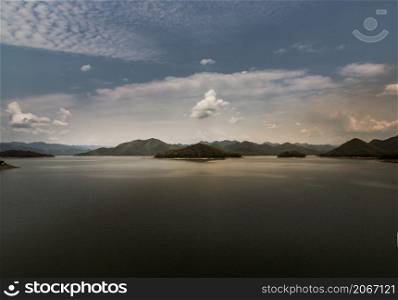 View of lake shore with mountains range in background at sunrise or sunset. Focus and blur.