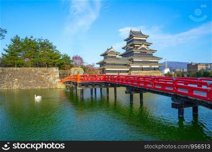 View of Matsumoto Castle with red bridge in Nagano, Japan.