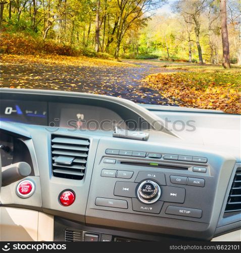 view of modern car dashboard with start power engine button and keys, fall road in background. car dashboard with keys