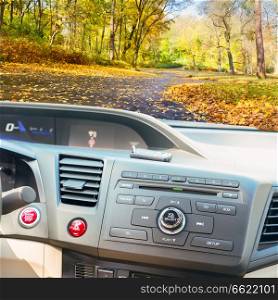 view of modern car dashboard with start power engine button and keys, fall road in background. car dashboard with keys