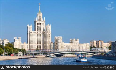 view of Moskva river with Bolshoy Ustinsky Bridge and tower building on Kotelnicheskaya embankment in Moscow city in sunny summer day