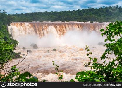 View of muddy Iguazu Falls at the border of Argentina and Brazil after heavy rain