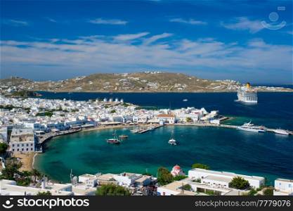View of Mykonos town Greek tourist holiday vacation destination with famous windmills, and port with boats and yachts and cruise liner. Mykonos, Cyclades islands, Greece. Mykonos island port with boats, Cyclades islands, Greece