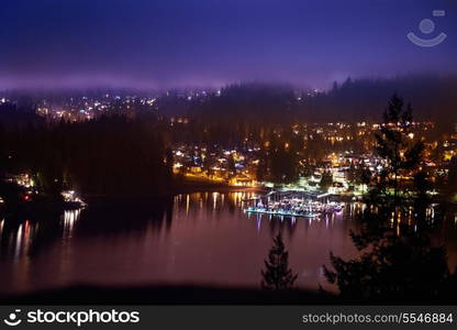 View of night city with lights and blue dramatic sky. North Vancouver, Canada