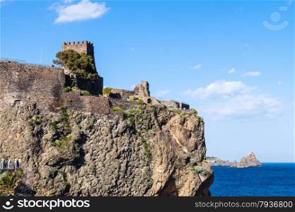 view of Norman castle in Aci Castello town and Cyclopean Rocks (Islands of the Cyclops), Sicily, Italy