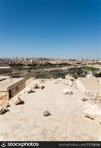 View of Old Jerusalem and Dome of the Rock on the Temple Mount from the Mount of Olives, Israel - selective focus on tombstone. Old Jerusalem Panorama from Mount of Olives