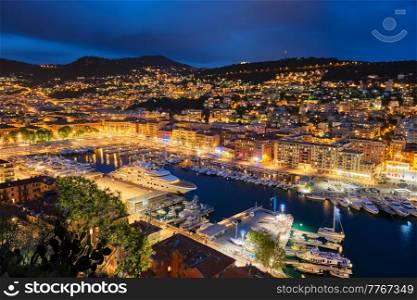 View of Old Port of Nice with luxury yacht boats from Castle Hill, France, Villefranche-sur-Mer, Nice, Cote d&rsquo;Azur, French Riviera in the evening blue hour twilight illuminated. View of Old Port of Nice with yachts, France in the evening