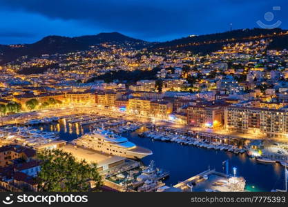 View of Old Port of Nice with luxury yacht boats from Castle Hill, France, Villefranche-sur-Mer, Nice, Cote d&rsquo;Azur, French Riviera in the evening blue hour twilight illuminated. View of Old Port of Nice with yachts, France in the evening