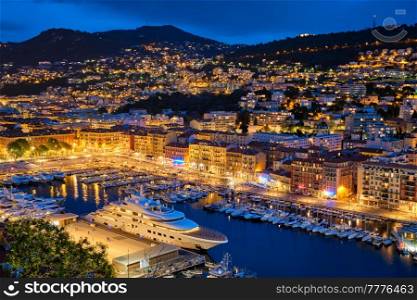 View of Old Port of Nice with luxury yacht boats from Castle Hill, France, Villefranche-sur-Mer, Nice, Cote d&rsquo;Azur, French Riviera in the evening blue hour twilight illuminated. View of Old Port of Nice with yachts, France in the evening