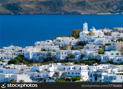 View of Plaka village with traditional Greek church and white painted houses and ocean coast. Milos island, Greece. View of Plaka village with traditional Greek church. Milos island, Greece