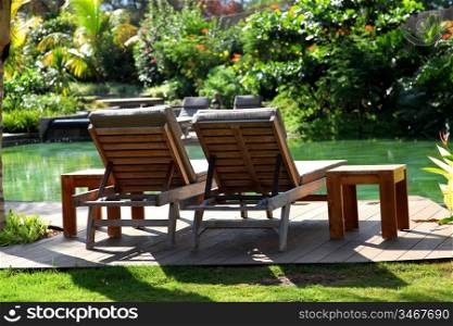 View of pool deck chairs in luxury resort gardens