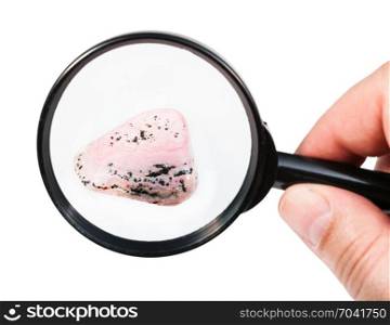 view of rhodochrosite gem stone through magnifier isolated on white background