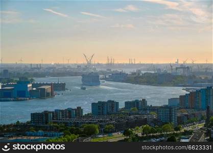 View of Rotterdam port and Nieuwe Maas river with cruise liner ship on sunset. View of Rotterdam city and Nieuwe Maas river