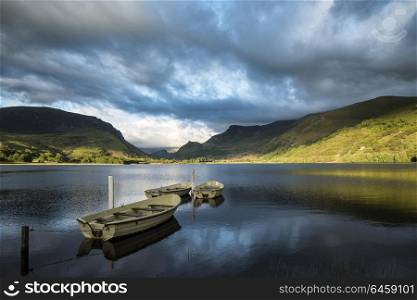 View of rowing boats on Llyn Nantlle in Snowdonia landscape at sunset