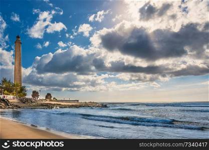 View of sea bay, sky with clouds and Maspalomas lighthouse at bright day. Gran Canaria, Spain