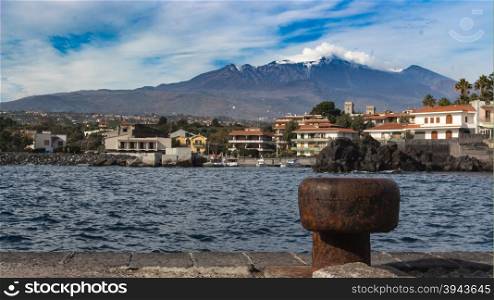 View of Sea port in sicily whit volcano Etna in background
