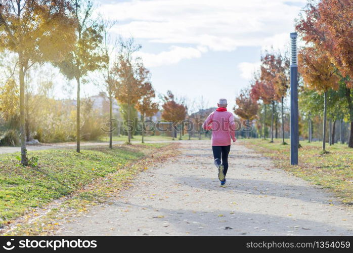 View Of Senior Man Jogging Through Park