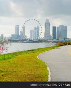 View of Singapore riverbank in Marina Barrage - popular place for workout and sport exercices. Singapore Flyer in the background