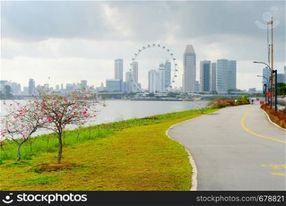 View of Singapore riverbank in Marina Barrage - popular place for workout and sport exercices. Singapore Flyer in the background