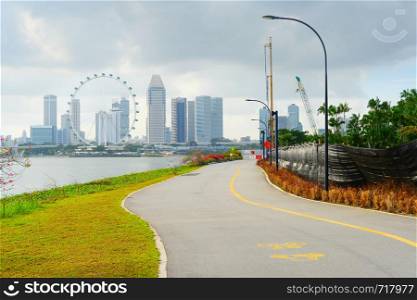 View of Singapore riverbank in Marina Barrage - popular place for workout and sport exercises. Singapore Flyer in the background