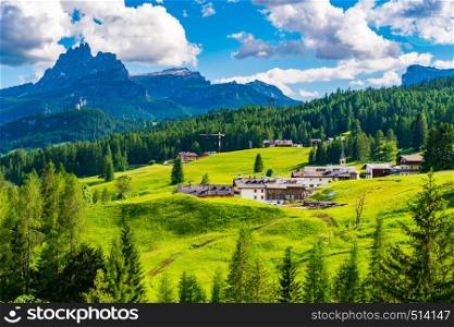 View of small village and the high mountain at the Giau Pass in Italy with the village and the forest of pine trees