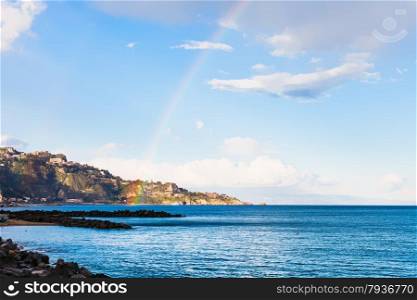 view of Taormina cape and rainbow in Ionian Sea in spring, Sicily