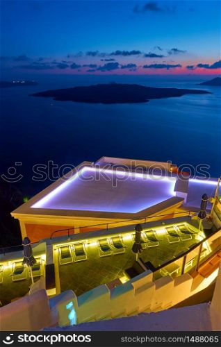 View of the Aegean Sea at twilight with swimming pool in the foreground, Santorini island, Greece. Greek landscape - cityscape