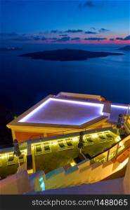 View of the Aegean Sea at twilight with swimming pool in the foreground, Santorini island, Greece. Greek landscape - cityscape