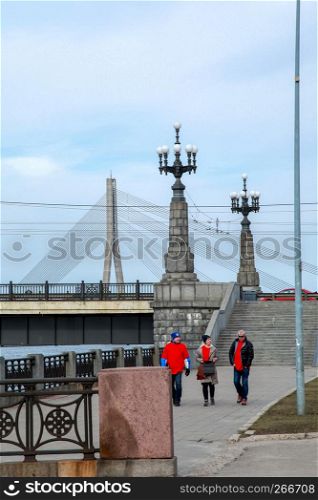 View of the Akmens bridge from the 11th November Embankment. Stairs to the stone bridge and lanterns in Riga, Latvia. Behind the Akmens bridge- Vansu bridge. Stone bridge in Riga city.