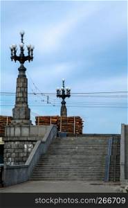 View of the Akmens bridge from the 11th November Embankment. Stairs to the stone bridge and lanterns in Riga, Latvia. Stairs to bridge on background of blue sky in Latvia. Stone bridge in Riga city.
