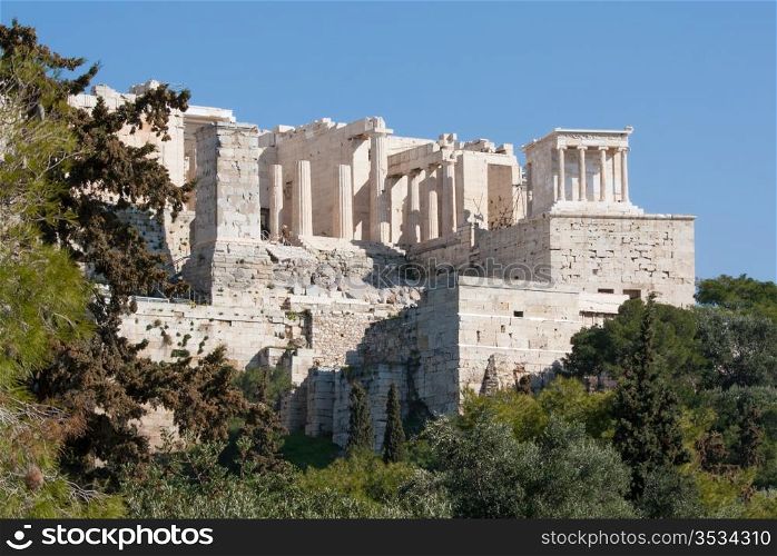 View of the ancient ruins of the Propylaia Gate and the Temple of Athena Nike on the Acropolis of Athens, Greece.