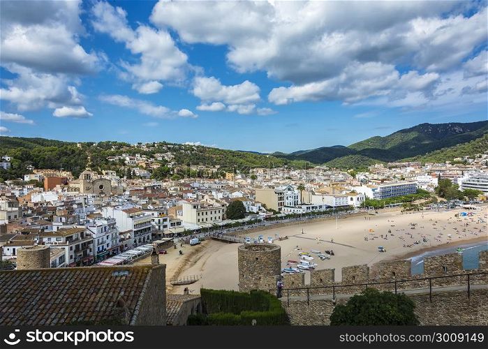 View of the beach, the promenade and the historic part of the city from the fortress of the old town (Tossa de Mar, Spain)