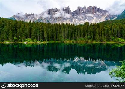 View of the beautiful Lake Carezza with the reflection of the famous Mount Latemar and the forest of Pine Trees at South Tyrol Region in Italy