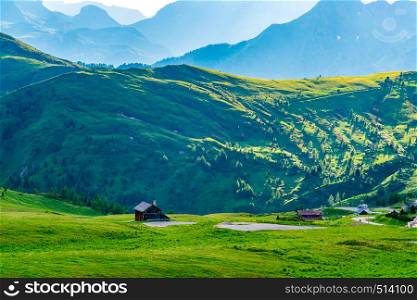 View of the beautiful mountains at the Giau Pass in Italy in the evening with the field of flowers and Italian cottage on the mountain