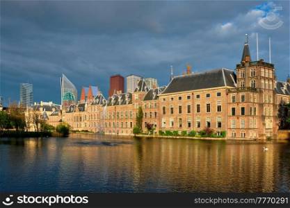 View of the Binnenhof House of Parliament and the Hofvijver lake with downtown skyscrapers in background. The Hague, Netherlands. Hofvijver lake and Binnenhof , The Hague
