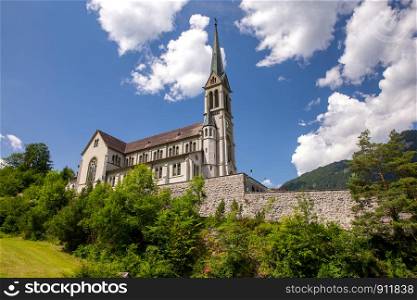 View of the catholic church in a swiss village on a sunny day. Lungern Switzerland.. Lungern Old stone catholic church in swiss village.