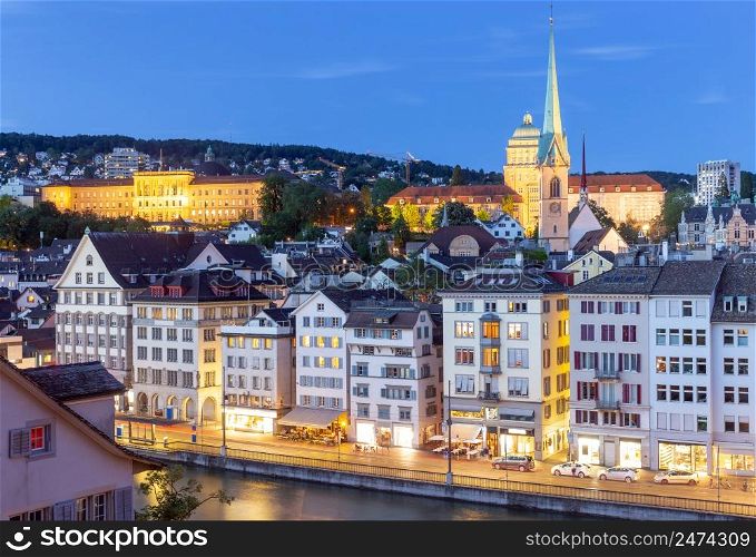 View of the city embankment and the clock tower at sunset. Zurich. Switzerland.. Zurich. View of the city embankment and the facades of old houses.