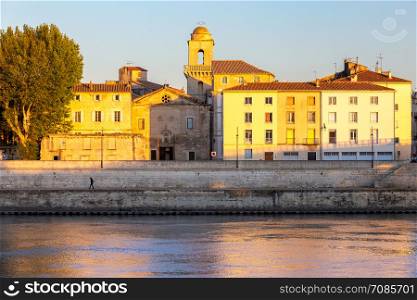 View of the city promenade in the night lights at sunset. Arles. France. Provence.. Arles. City embankment and facades of old houses at sunset.